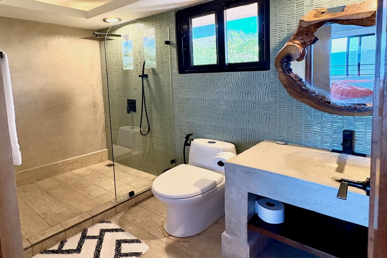 Private bathroom of the Wave View Room at Miramar SurfCamp with walk-in shower