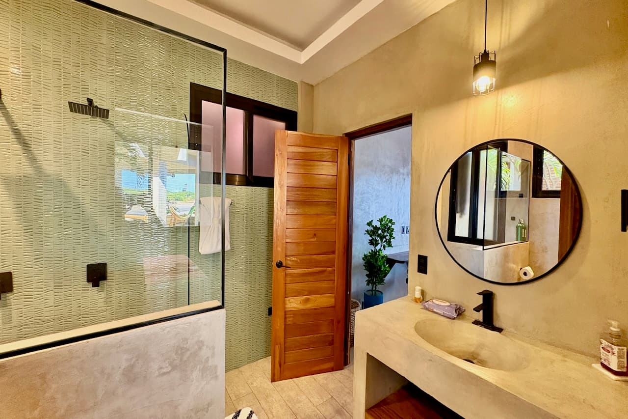 Spacious private bathroom with modern shower in the Ocean Master Room at Miramar SurfCamp